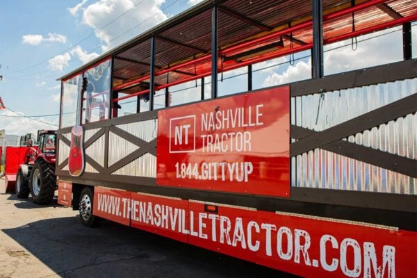 Red tractor pulling a party wagon for the Nashville Tractor tour in downtown Nashville.