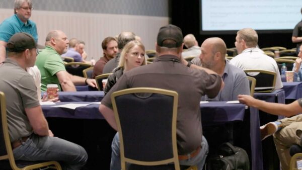 Conference attendees engaged in roundtable discussions during a breakout session.