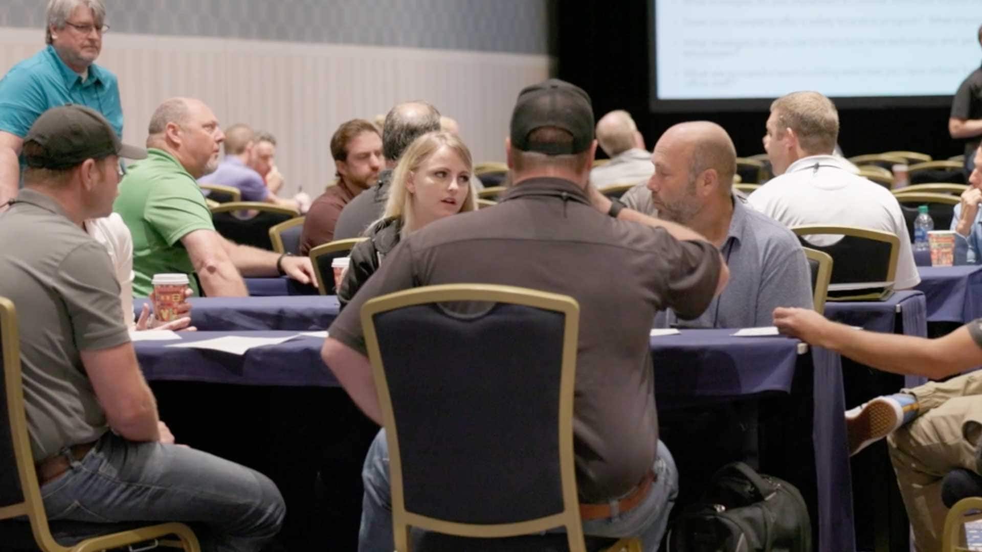 Conference attendees engaged in roundtable discussions during a breakout session.
