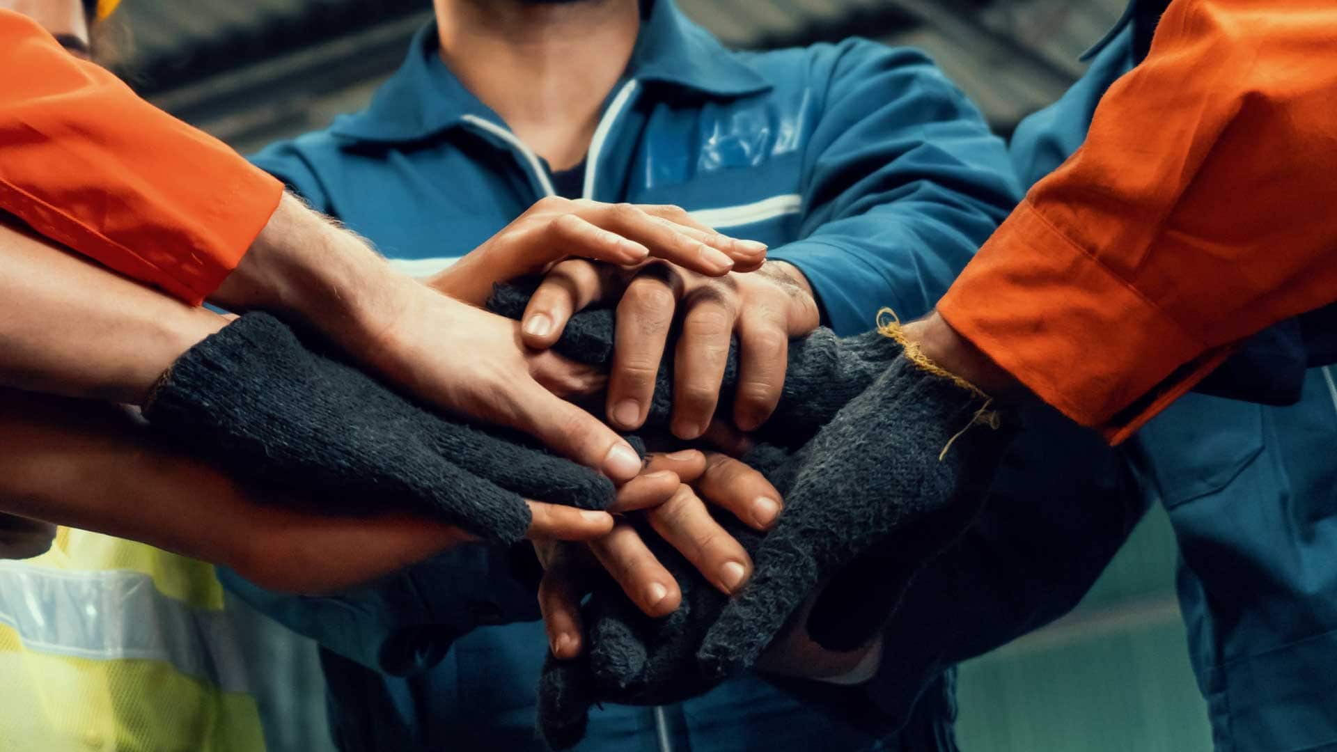 Employees stacking hands in a show of teamwork and unity.