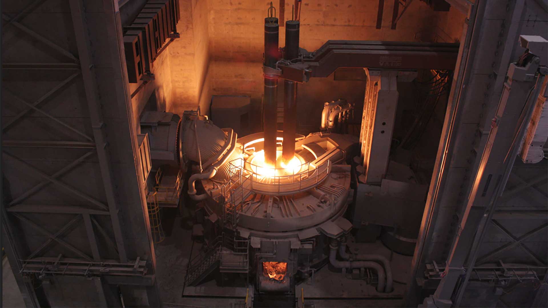 Electric arc furnace operating inside a steel production facility during stainless steel manufacturing.